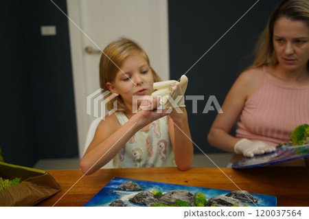 A mother and her daughter craft vibrant natural landscapes  120037564