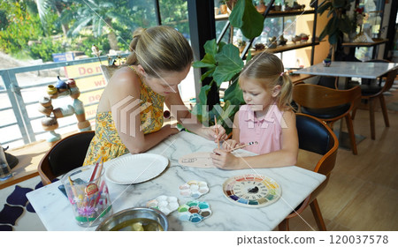 A young mother and her daughter enjoy a creative art session at home A young mother and her daughter enjoy a creative art session at home 120037578