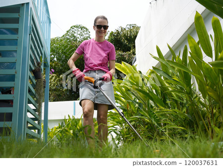 A young woman trims her beautiful garden A young woman trims her beautiful garden 120037631