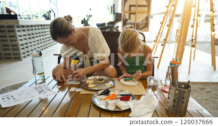 Mother and her daughter paint Halloween cookies Mother and her daughter paint Halloween cookies 120037666