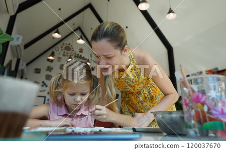 A young mother and her daughter enjoy a creative art session at home A young mother and her daughter enjoy a creative art session at home 120037670