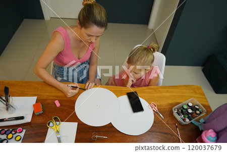 A mother and her young daughter engage in a colorful painting activity A mother and her young daughter engage in a colorful painting activity 120037679