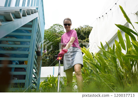 A young woman trims her beautiful garden  120037713