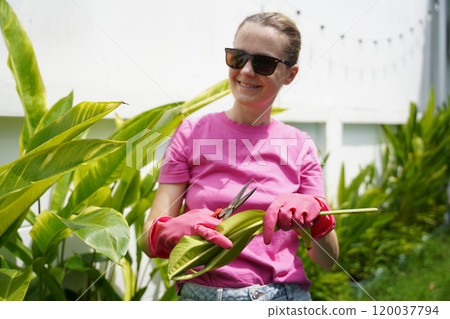 A young woman trims her beautiful garden A young woman trims her beautiful garden 120037794