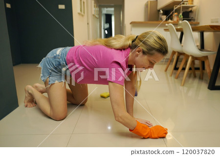 A woman is cleaning her living room at home A woman is cleaning her living room at home 120037820