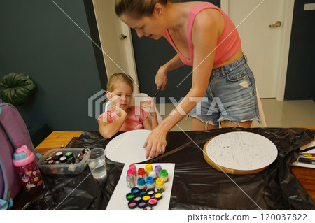 A mother and her young daughter engage in a colorful painting activity A mother and her young daughter engage in a colorful painting activity 120037822