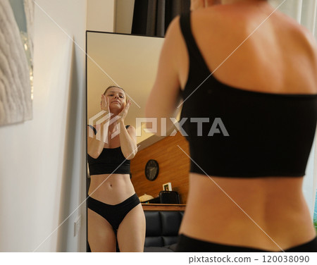 A young woman is enjoying a wonderfully serene morning in her bedroomnd A young woman is enjoying a wonderfully serene morning in her bedroomnd 120038090