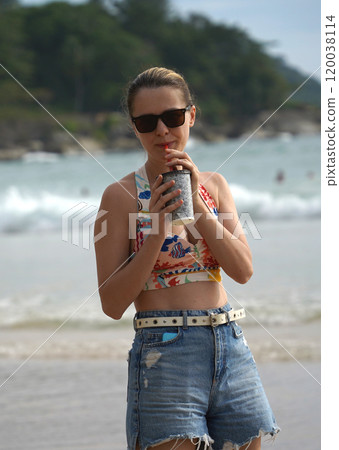 A young woman enjoying a beautiful day at the beach  120038114