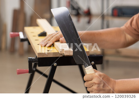 Senior man Cutting Dovetails With Woodworking Hand Tool for Hobby After retirement. 120039326