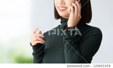 微笑的女人/女商人在智慧型手機上交談 120041439
