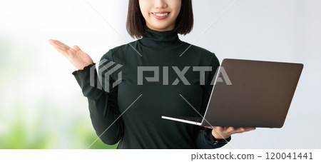 A smiling woman/businesswoman giving directions while holding a computer 120041441