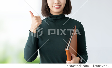 A young woman/businesswoman making a thumbs up pose A young woman/businesswoman making a thumbs up pose 120042549