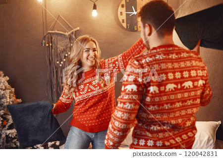 People in a Christman decorations. Man and woman in a red sweater. Family at home. People in a Christman decorations. Man and woman in a red sweater. Family at home. 120042831