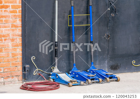Three car jacks at the garage door. 120043253