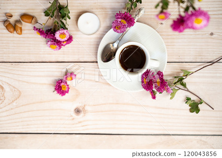 Autumn, fall leaves, hot steaming cup of coffee and a warm scarf on wooden table background. Seasonal, morning coffee, Sunday relaxing and still life concept. Autumn, fall leaves, hot steaming cup of coffee and a warm scarf on wooden table background. Seasonal, morning coffee, Sunday relaxing and still life concept. 120043856