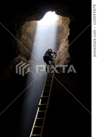 Life beneath earth: a mine worker focused on excavation in a subterranean environment showcasing the hard work, persistence, and skill involved in the mining profession. 120043979
