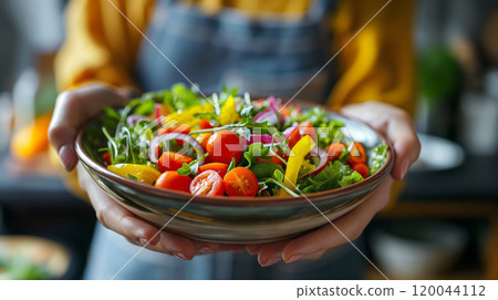 Freshly prepared vegetable salad with colorful ingredients served in a rustic bowl in a cozy kitchen setting 120044112