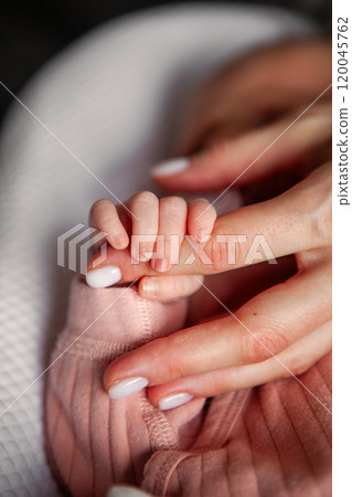 Close Up Newborn Baby Hand Grasping Mother Finger Tenderly, Heartwarming Moment of Connection and Love Between Mom and Child Close Up Newborn Baby Hand Grasping Mother Finger Tenderly, Heartwarming Moment of Connection and Love Between Mom and Child 120045762