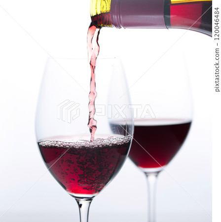 Pouring red wine into a wine glass Pouring red wine into a wine glass 120046484