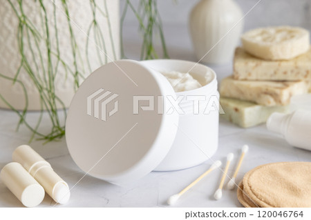 Opened cream jar with white blank lid on marble near green plant close up, cosmetic mockup Opened cream jar with white blank lid on marble near green plant close up, cosmetic mockup 120046764