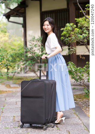 一位年輕女子背著行李箱返回鄉村的旅行形象 一位年輕女子背著行李箱返回鄉村的旅行形象 120047240