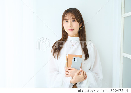 有筆記本和智慧型手機的年輕女子 有筆記本和智慧型手機的年輕女子 120047244