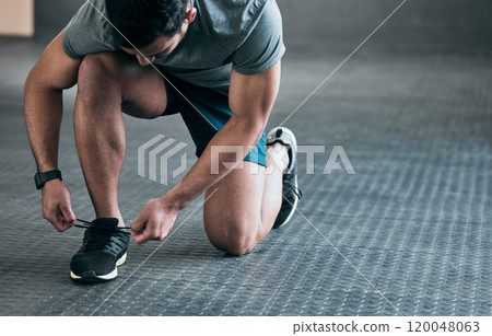 Fitness, gym and man tie shoes for workout, training and exercise in health center with feet. Hands, shoelace and sport facility with runner sneakers, legs and kneeling on ground for wellness 120048063