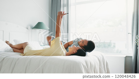 Couple, smile and selfie on bed in home for profile picture update, social media post and memory. People, photography and bonding in bedroom with laughing, live streaming or relationship in apartment Couple, smile and selfie on bed in home for profile picture update, social media post and memory. People, photography and bonding in bedroom with laughing, live streaming or relationship in apartment 120048426