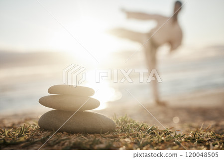 Rocks, pile and beach with man in zen for karate, martials arts training or taekwondo in nature. Closeup of stack or stones by ocean coast with male person in self defense for outdoor awareness 120048505