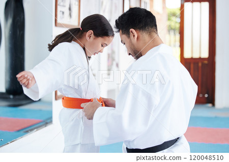 Karate, martial arts and child with teacher in dojo for learning aikido, taekwondo and jiujitsu. Sports, hobby and sensei help girl with belt for fitness, exercise and workout for self defense class 120048510