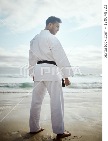 Warrior, karate and man at beach for exercise, training or thinking of martial arts outdoor. Fighter, person or practice taekwondo at ocean for fitness, sport or workout body with back view in summer 120048523
