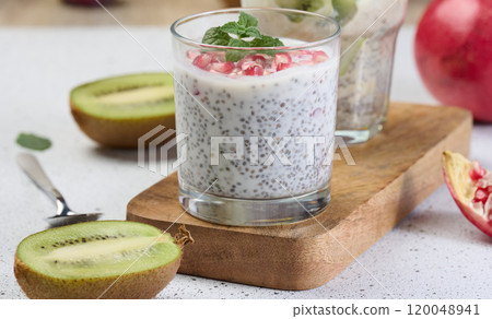 Two glasses of chia yogurt dessert garnished with fresh fruit, pomegranate seeds and kiwi slices Two glasses of chia yogurt dessert garnished with fresh fruit, pomegranate seeds and kiwi slices 120048941
