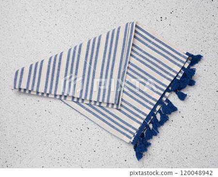 Folded linen striped kitchen towel on a white background 120048942