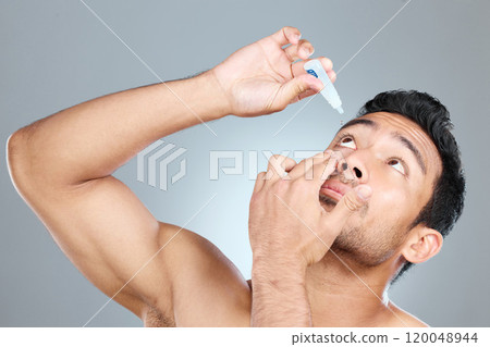 Model, eye drops and vision in studio for healthcare, eyesight and medical product for allergies. Shirtless man, liquid solution and eyes to stop allergy, self care and wellness on gray background 120048944