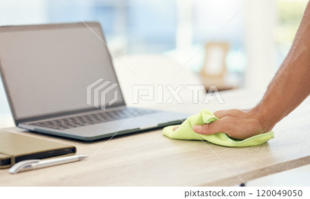 Man, laptop and hand cleaning desk for hygiene, bacteria and dirt or dust in modern office. Employee, computer and wiping table with cloth for disinfection, healthcare and safety from germ risk 120049050