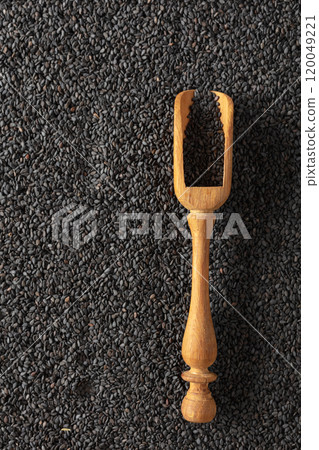 Black sesame seeds and wooden spoon. 120049221