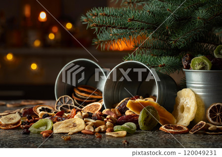 Sweet tropical fruits and Christmas tree on a kitchen table. 120049231