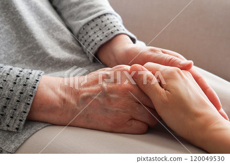 Senior woman's hand holding another woman's hand 120049530