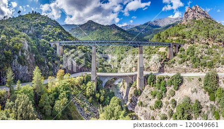 Railway bridge spanning rugged Corsican mountains, showcasing engineering amidst scenic nature Railway bridge spanning rugged Corsican mountains, showcasing engineering amidst scenic nature 120049661