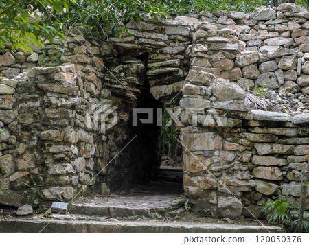Door in the wall entrance of the Tulum maya historical archeological site yucatan mexico 120050376