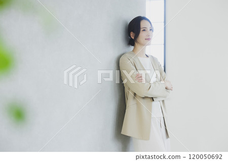 Young woman in a suit with her arms crossed 120050692