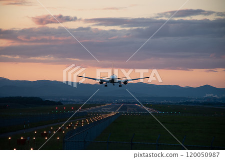 Jet plane landing at an airport at dusk 120050987