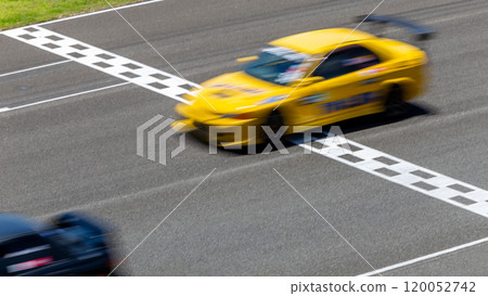 Motion blur race car racing on speed track, Car race on the international circuit race track crossing start and finish line, Race car crossing start and finish line, Target business achieve victory. Motion blur race car racing on speed track, Car race on the international circuit race track crossing start and finish line, Race car crossing start and finish line, Target business achieve victory. 120052742