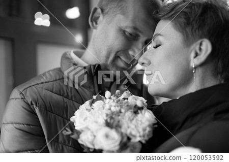 A couple walks through the city at night, sharing a tender moment A couple walks through the city at night, sharing a tender moment 120053592