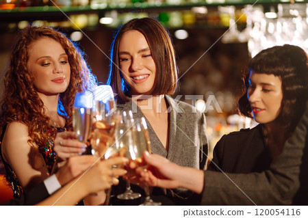 Cheering, drinking cocktails. Group of friends partying in nightclub and toasting drinks cocktails. 120054116