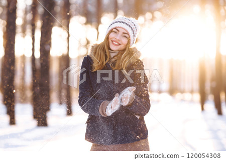 Happy woman plays with snow in sunny winter day. Girl enjoys winter, frosty day. Playing with snow. Happy woman plays with snow in sunny winter day. Girl enjoys winter, frosty day. Playing with snow. 120054308