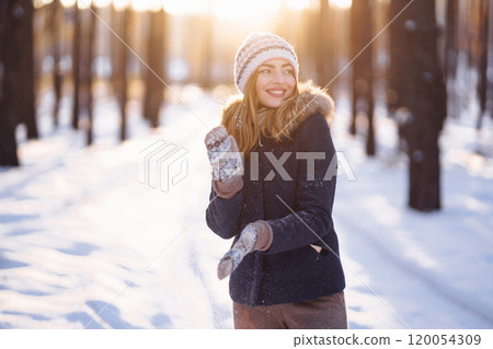 Happy young woman plays with a snow in sunny winter day. Girl enjoys winter, frosty day. Happy young woman plays with a snow in sunny winter day. Girl enjoys winter, frosty day. 120054309