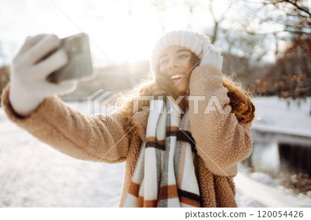 Young woman taking selfie in winter street. Holidays, rest, blogging. 120054426