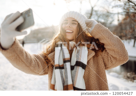 Young woman taking selfie in winter street. Holidays, rest, blogging. 120054427