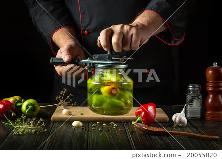 Preserving green bell pepper in a spice jar. A chef uses a manual seaming key to seal a jar of pickled peppers 120055020
